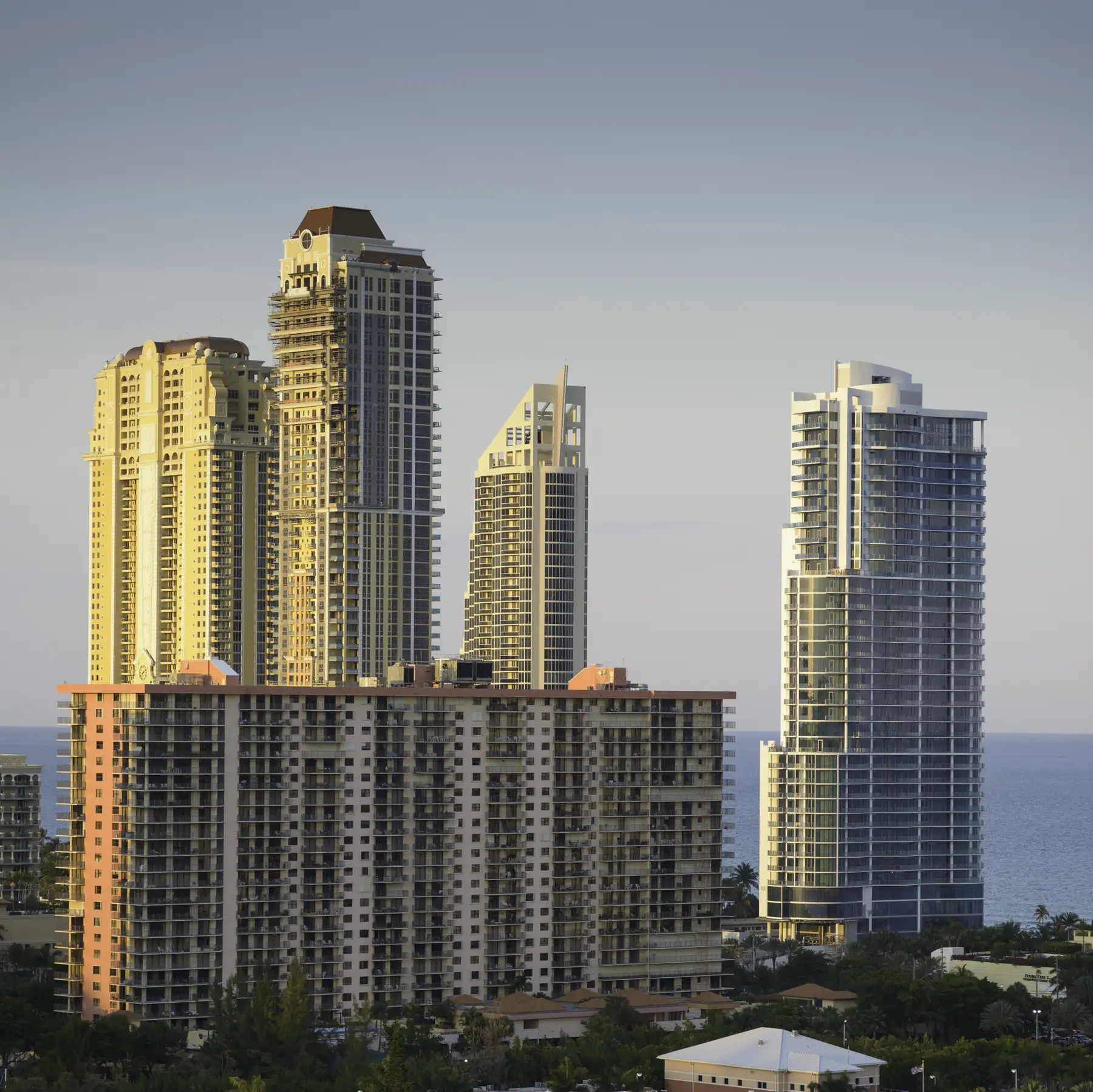 Château Beach (right, white and blue glass) seen from the west, with towers to the north behind — Château Beach Residences, Sunny Isles Beach
