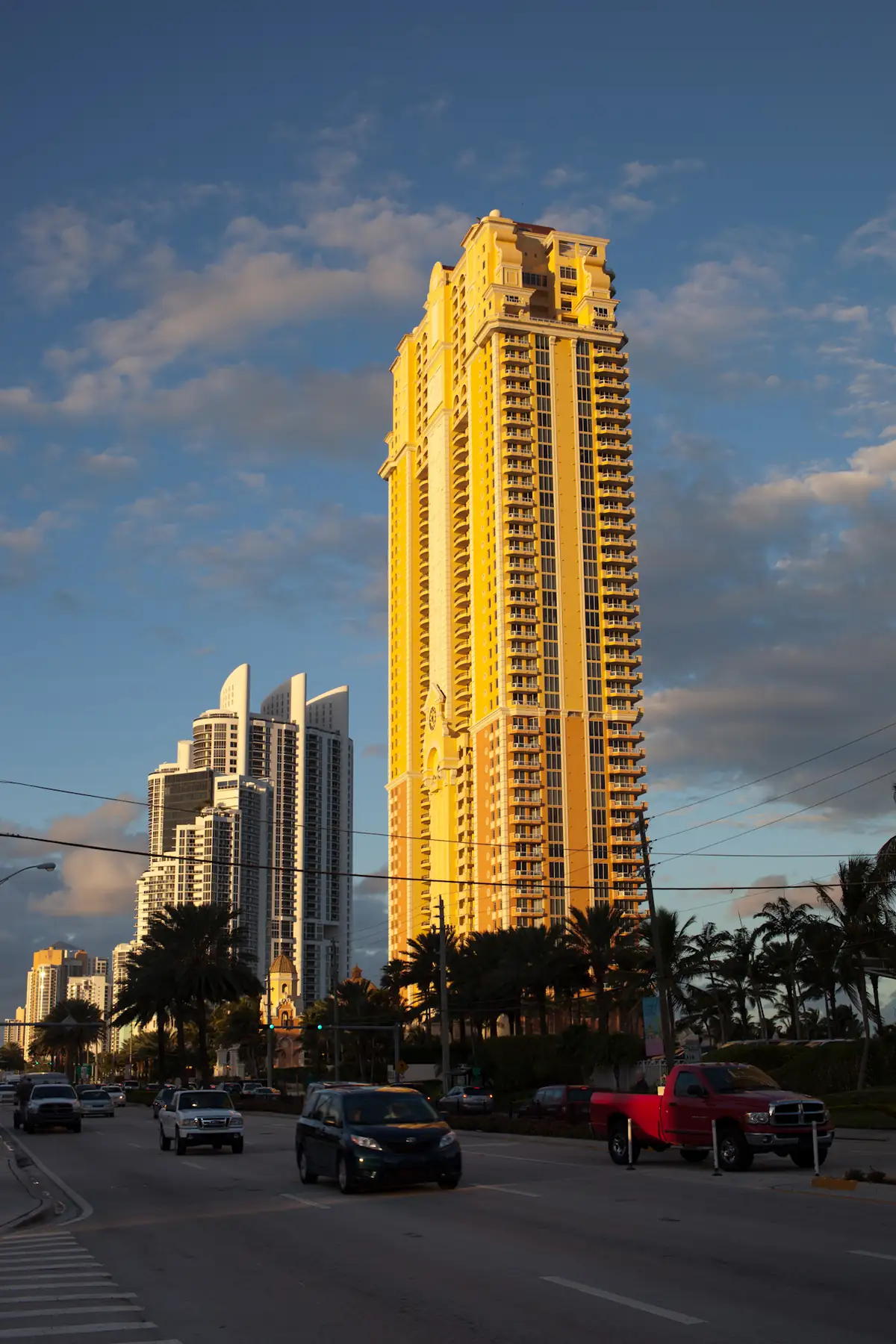 The Acqualina tower glowing at sunset over Collins Avenue