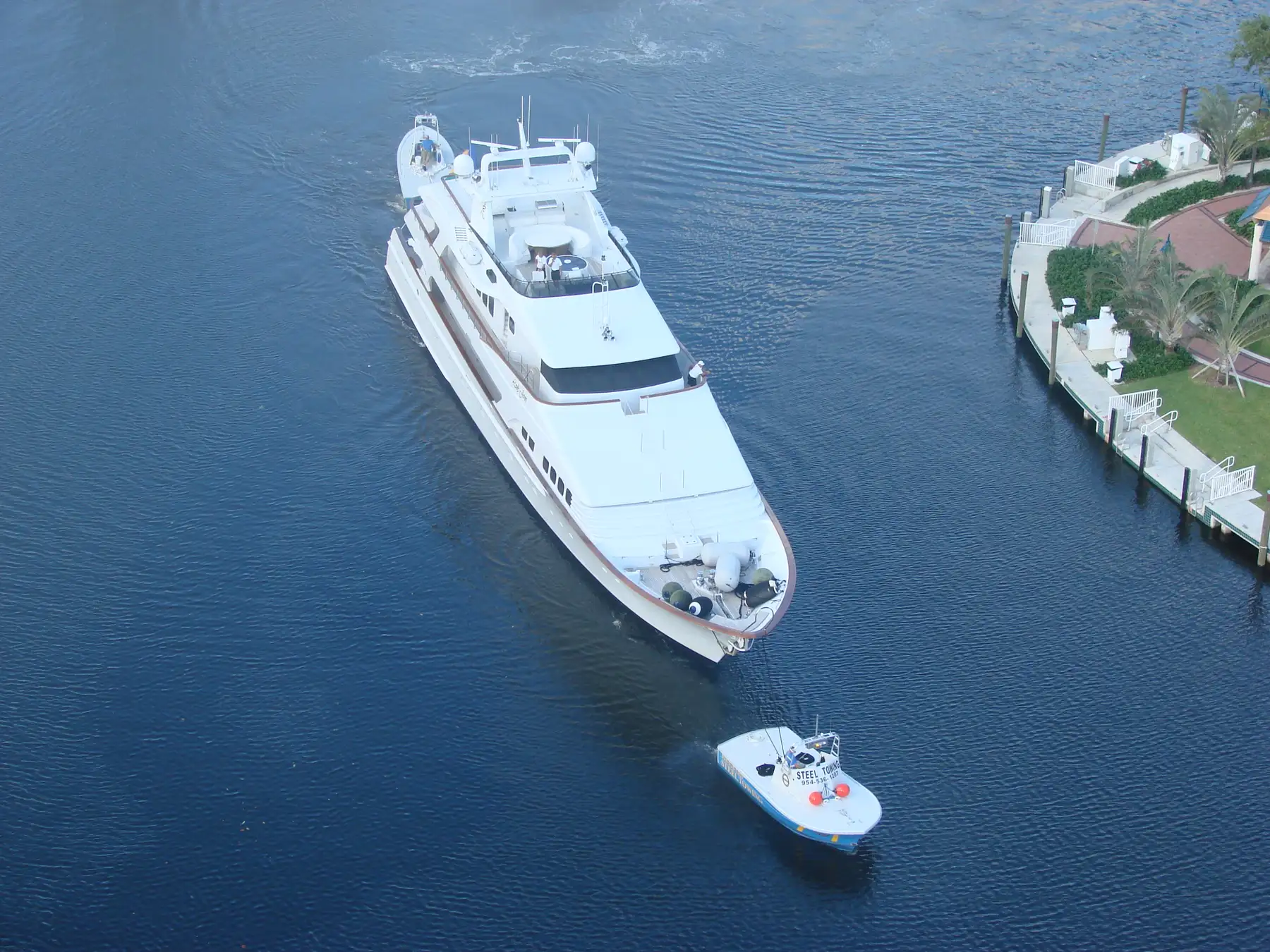 A yacht under tow on the New River, seen from above — Las Olas Grand, Fort Lauderdale