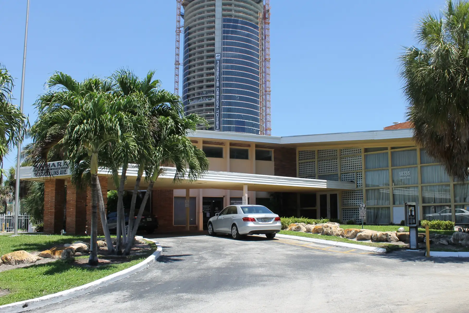 Porsche Design Tower under construction in 2015, behind a mid-century motel on Collins Avenue — Porsche Design Tower, Sunny Isles Beach