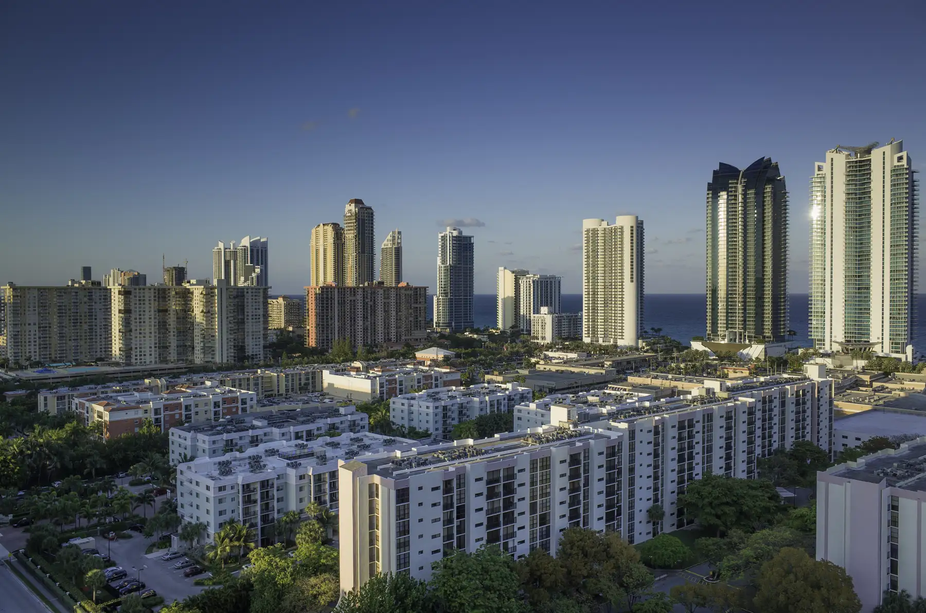 Sunny Isles from the west: bay-side mid-rises in front, oceanfront towers behind — Winston Towers 600, Sunny Isles Beach